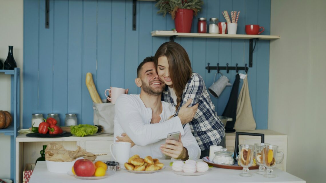 Sabah mutfakta birbirine sarılıp gülümseyen bir çift